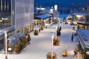 a city street decorated with christmas trees and lights at Lapinmaa Apartments in Rovaniemi
