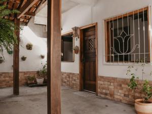 an entrance to a house with a wooden door at Flats Beija-Flor in Itacaré