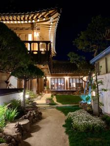 une maison de nuit avec un chemin menant à celle-ci dans l'établissement HanokInn, à Gyeongju