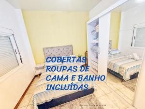 1 dormitorio con 1 cama y 1 silla en Incrível Sacada à Beira Mar APTO 3Q en Tramandaí