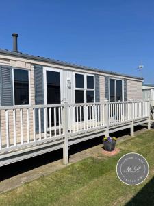 a mobile home with a white fence at Golden Palm Resort - The Pastures 57 - TP57 in Chapel Saint Leonards