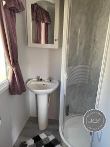 a small bathroom with a sink and a shower at Golden Palm Resort - The Pastures 57 - TP57 in Chapel Saint Leonards