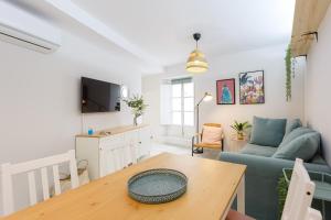 ein Wohnzimmer mit einem Tisch und einem blauen Sofa in der Unterkunft Apartamento El NOBLE by Cadiz4Rentals in Cádiz