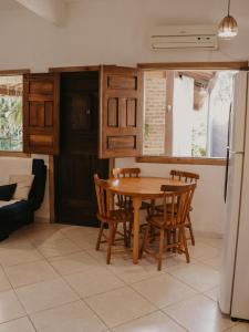 a kitchen with a wooden table and chairs at Flats Beija-flor Itacaré in Itacaré +10 photos