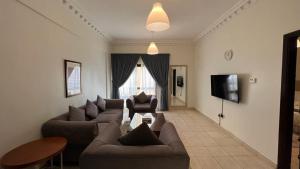 a living room with two couches and a tv at Kuwait Residence in Kuwait