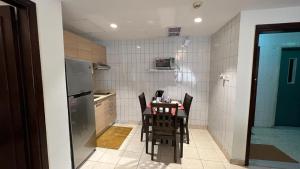 a small kitchen with a table and chairs in it at Kuwait Residence in Kuwait