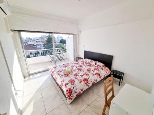 een slaapkamer met een bed en een groot raam bij City View Rooms in Larnaka