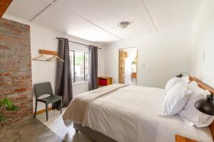 a bedroom with a bed and a brick wall at Arendsig Wine Estate & Cottages in Bonnievale