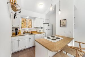 a kitchen with white cabinets and a wooden counter top at Mill Run 3D in Quechee