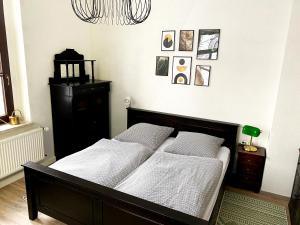 een slaapkamer met een bed met witte lakens en een kroonluchter bij Zitronenhaus in Bad Frankenhausen