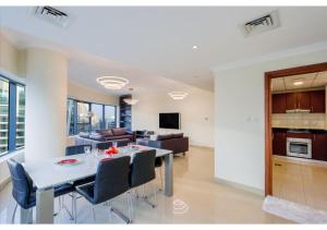 a dining room and living room with a table and chairs at Spacious 3 BR Suite with Marina View - Near Marina Mall in Dubai
