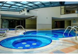 a large blue swimming pool in a building at Spacious 3 BR Suite with Marina View - Near Marina Mall in Dubai