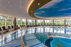 兹拉蒂博尔A Hoteli - Grand&Sky Hotel Tornik的建筑物内设有带椅子的大型游泳池