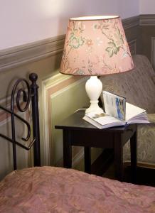 a lamp sitting on a table next to a bed at Apartamenty Gołębia 3 in Krakow