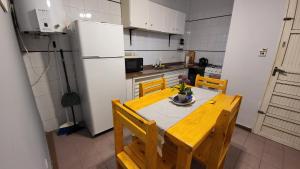 cocina con mesa, sillas y nevera en Depto Temporario Centro Corrientes en Corrientes