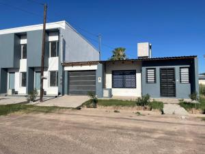 una casa azul y blanca con entrada en LOS ABRILES en General Alvear