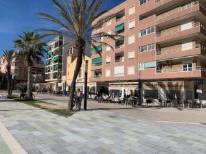 a person riding a bike in front of a building at Modern Apartment Near Beach in La Mata