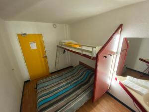 Habitación pequeña con litera y puerta amarilla en Class'Eco Albi en Albi