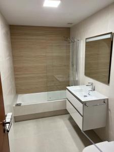 a bathroom with a tub and a sink and a shower at Playa Nigrán in Nigrán