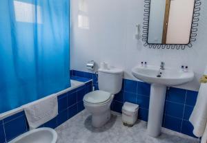 baño azul y blanco con aseo y lavamanos en Hotel Las Errizas by Vivere Stays, en Alcalá del Valle