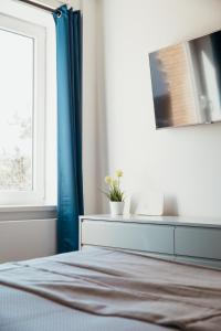 1 dormitorio con 1 cama con cortinas azules y ventana en StrandBude, en Grömitz