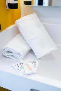 a pile of towels sitting on a counter in a bathroom at B&B HOTEL Bordeaux Bassins à flot in Bordeaux