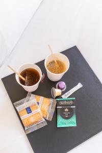 a table with two cups of tea and a cup of coffee at B&B HOTEL Bordeaux Bassins à flot in Bordeaux