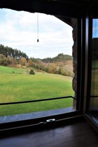 een raam met uitzicht op een grasveld bij Eguen Goiko in Lekeitio