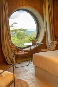 Zimmer mit einem großen Fenster, einem Tisch und Stühlen in der Unterkunft Tava Cerro in San Bernardino