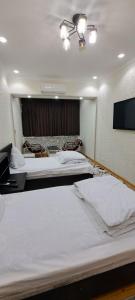 Habitación de hotel con 2 camas y TV de pantalla plana. en Апартамент в центре города Худжанд en Khujand