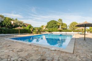 a swimming pool in a yard with umbrellas at El nido de Betlem in Colonia de Sant Pere