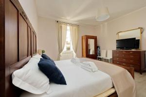 ローマにあるCasa Testaccioのベッドルーム(青い枕の大きな白いベッド付)