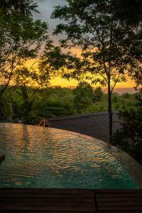 a swimming pool with a sunset in the background at Tava Cerro in San Bernardino