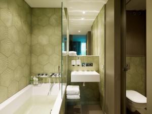 a bathroom with a tub and a sink and a toilet at VISIONAPARTMENTS Berlin - contactless check-in in Berlin