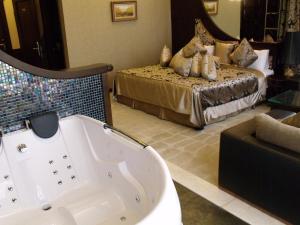 uma casa de banho com banheira e uma cama em Riviera Hotel em Baku