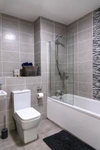 a bathroom with a toilet and a tub and a sink at Stylish Jewellery Quarter Apartment Sleeps 6 in Birmingham