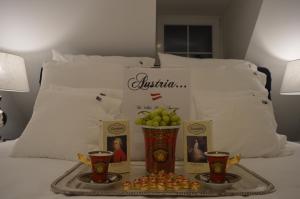 bandeja de fruta y dos tazas en una cama en The White House Austria, en Lind ob Velden