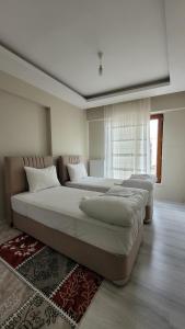 due ampi letti in una camera da letto con finestra di Padishah Suite Otel a Van