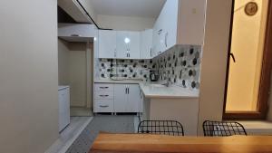 a kitchen with white cabinets and a table and chairs at Padishah Suite Otel in Van
