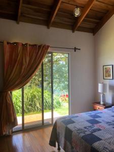 a bedroom with a bed and a large sliding glass door at Casa Sofia, a Gem Close to Orosi Thermal Pools! in Orosí