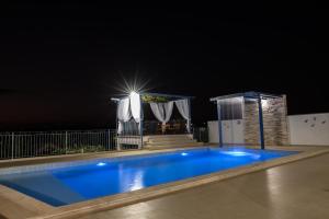 a swimming pool at night with a light at Casa Florida do Lago in Guapé