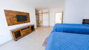 a bedroom with a bed and a tv on a wall at Urbanización privada, seguridad y confort in Manta