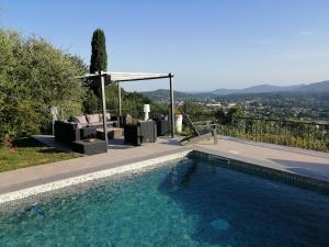 una piscina con sillas y un cenador junto a en Les lodges de l'oliveraie de Virevent, en Grasse