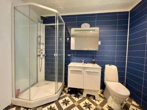 a blue tiled bathroom with a toilet and a shower at 6 person holiday home in Huglo-By Traum in Nordhuglo +55 photos