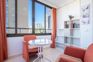 sala de estar con mesa, sillas y ventana en Trinisol 7-A Sea Views Apartment Levante Beach, en Benidorm