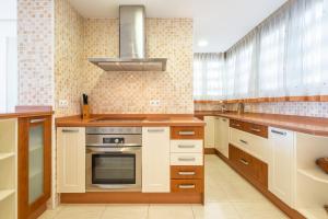 a kitchen with white cabinets and a stove top oven at Trinisol 7-A Sea Views Apartment Levante Beach in Benidorm