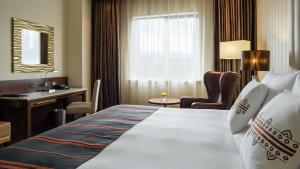 アディスアベバにあるRadisson Blu Hotel, Addis Ababaの大きなベッドとデスクが備わるホテルルームです。