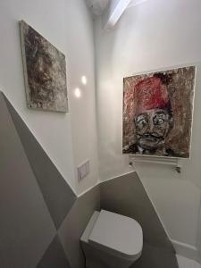 ナポリにあるAttikのバスルーム(トイレ付)が備わります。壁に絵画が飾られています。