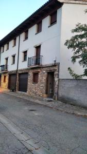 een wit gebouw met ramen en een straat bij Casa ARVIPIRINEOS in Santa Engracia