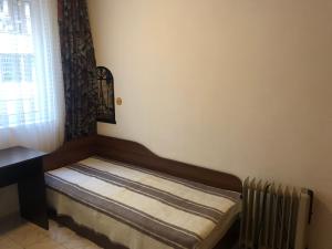 uma cama num quarto com uma janela e um radiador em Гарсониера Жорката em Varna City